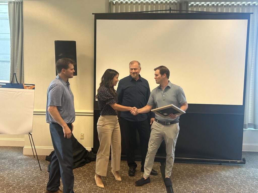 The management team presents Brian Grossweiler an certificate of recognition of his new role as CEO at the annual SKO event.